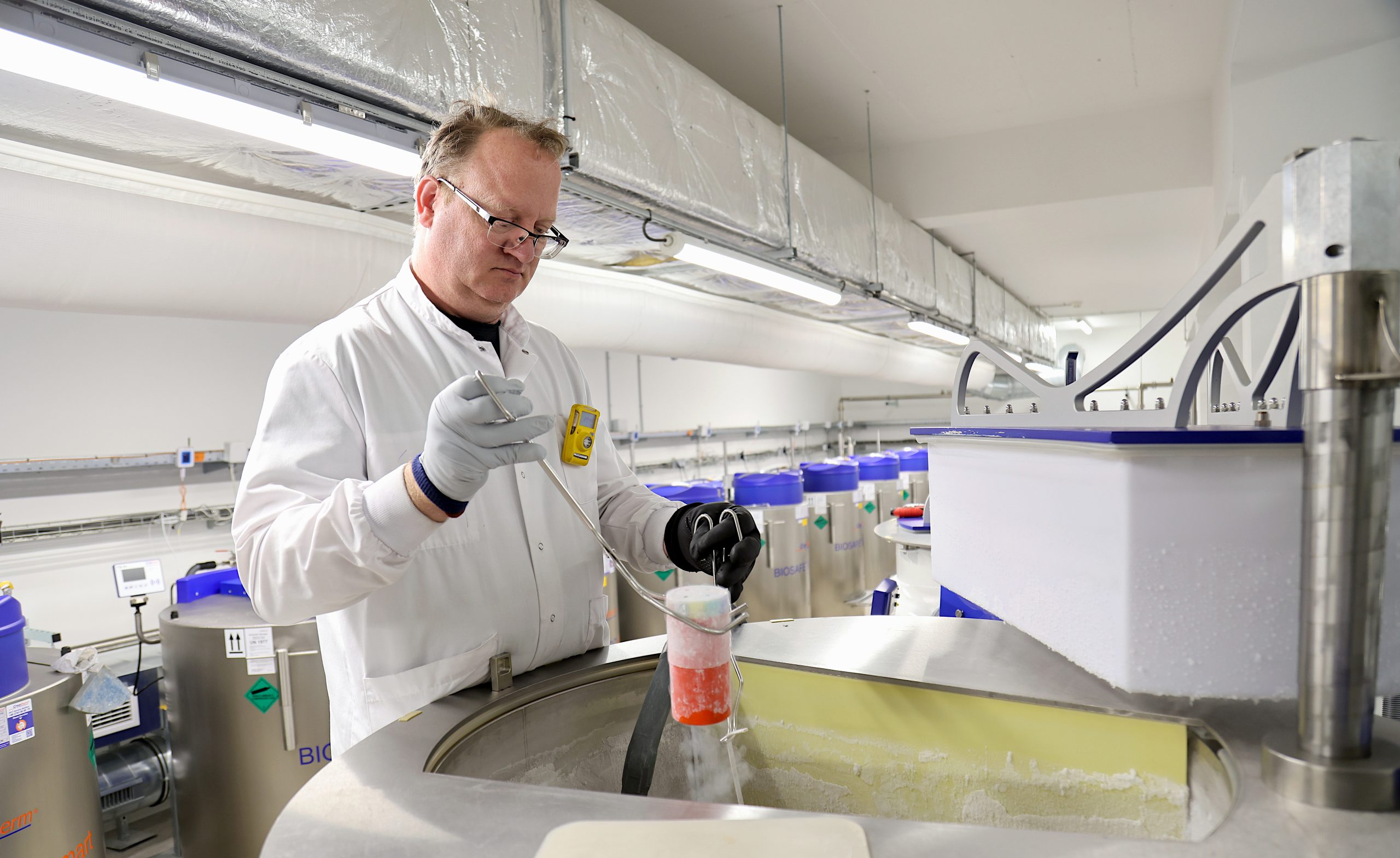 A man wearing a white medical gown at IARC Biobank