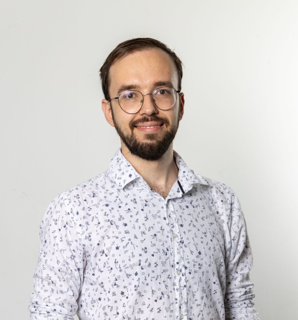 The picture of a man wearing glasses and a white shirt, looking at the camera.